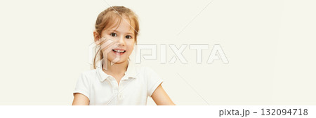 Smiling caucasian young girl in white shirt with light brown hair against soft 132094718