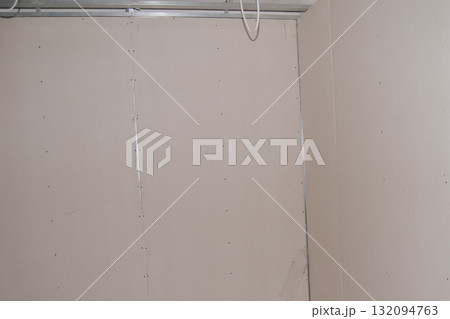 Corner of the room covered with drywall. 132094763
