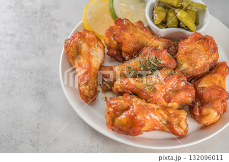 Savor the irresistible allure of these delicious, spicy buffalo chicken wings. Crispy, cooked to perfection and coated in a flavorful sauce, they are sprinkled with sesame seeds 132096011