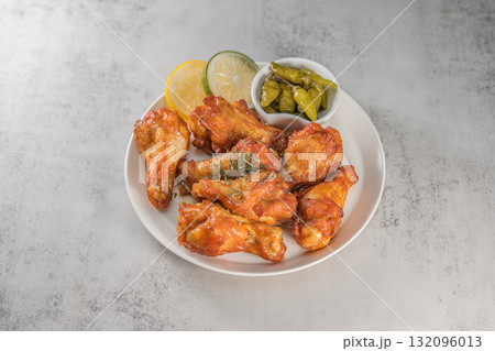 Savor the irresistible allure of these delicious, spicy buffalo chicken wings. Crispy, cooked to perfection and coated in a flavorful sauce, they are sprinkled with sesame seeds 132096013