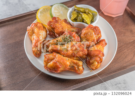 Savor the irresistible allure of these delicious, spicy buffalo chicken wings. Crispy, cooked to perfection and coated in a flavorful sauce, they are sprinkled with sesame seeds Savor the irresistible allure of these delicious, spicy buffalo chicken wings. Crispy, cooked to perfection and coated in a flavorful sauce, they are sprinkled with sesame seeds 132096024