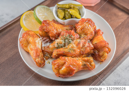 Savor the irresistible allure of these delicious, spicy buffalo chicken wings. Crispy, cooked to perfection and coated in a flavorful sauce, they are sprinkled with sesame seeds 132096026