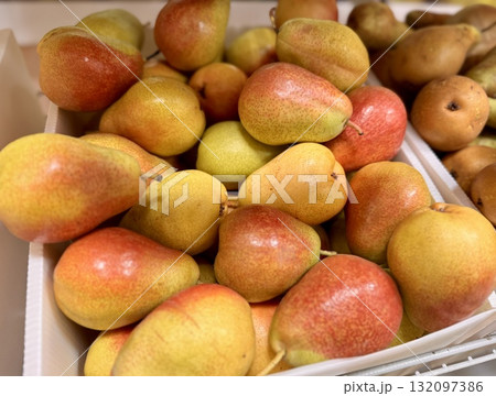 A bountiful collection of fresh, ripe red yellow pears beautifully nestled in a charming basket, perfect for healthy eating. Close-up. A bountiful collection of fresh, ripe red yellow pears beautifully nestled in a charming basket, perfect for healthy eating. Close-up. 132097386