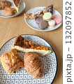 French breakfast table with croissants, quiche slice, colorful macarons on 132097852