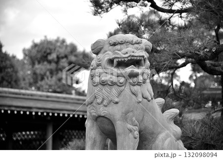 Stone lion statue with intricate carvings, set against a blurred background of Buddhist temple Stone lion statue with intricate carvings, set against a blurred background of Buddhist temple 132098094