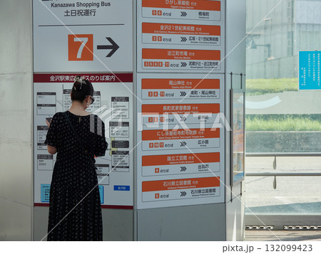 夏の観光地金沢駅西口のバス停で時間を確認する女性観光客の姿 夏の観光地金沢駅西口のバス停で時間を確認する女性観光客の姿 132099423