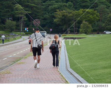 夏の観光地金沢城の通りで歩くカップルの外国人観光客 132099433