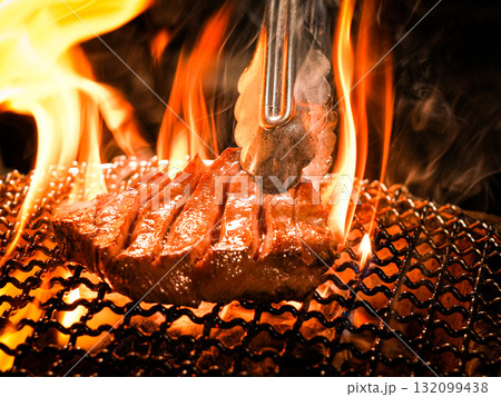 炭火の炎で焼かれるステーキ肉 132099438
