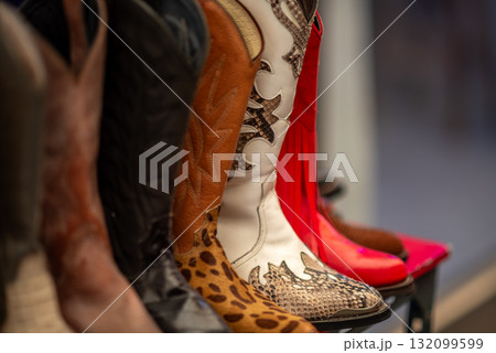 A row of colorful cowboy boots with various patterns A row of colorful cowboy boots with various patterns 132099599