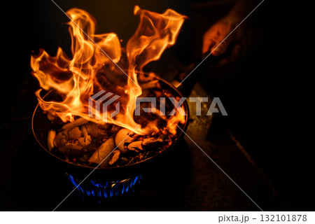 Chef Cooking with Fire Flame in frying iron pan Chef Cooking with Fire Flame in frying iron pan 132101878