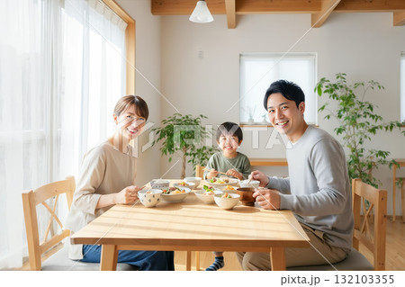 明るい自然光の下で笑顔を見せる日本の3人家族 132103355