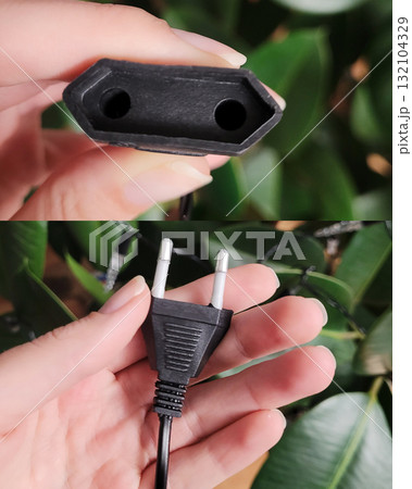 Black Electrical Plug in Hand Close-Up Black Electrical Plug in Hand Close-Up 132104329