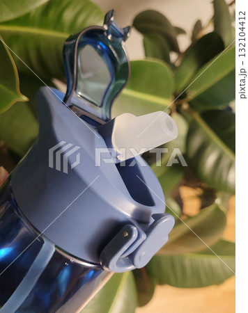 Blue Water Bottle in Hand Near Plant Blue Water Bottle in Hand Near Plant 132104412