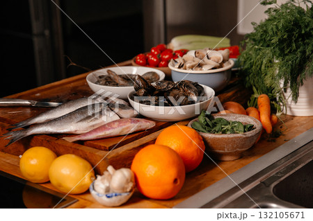 Sea bream and shells on the table next to vegetables Sea bream and shells on the table next to vegetables 132105671