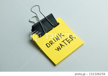 A bright yellow note with a reminder to drink water 132106256