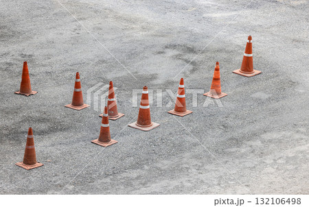row of orange fluorescent, reflex traffic cones on road. 132106498