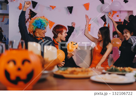 Joyful office Halloween party with coworkers in costumes, celebrating with drinks and laughter, fostering teamwork and festive spirit 132106722