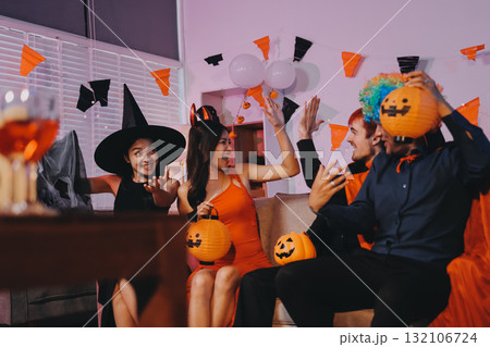 Joyful office Halloween party with coworkers in costumes, celebrating with drinks and laughter, fostering teamwork and festive spirit 132106724