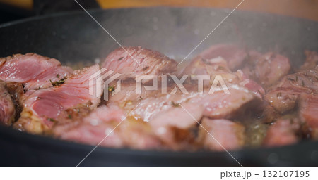 Delicious Juicy Beef Meat Cooking on Pan Seasoned Herbs. Delicious Juicy Beef Meat Cooking on Pan Seasoned Herbs. 132107195