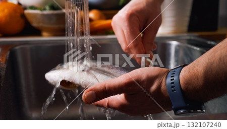 Cleaning Fish on Water Jet Before Cooking. Gilt-head bream fish. 132107240