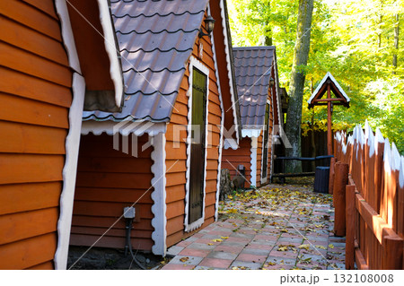This video captures a serene relaxation area in a forested setting. Rustic hut structures are nestled among lush green trees, offering a peaceful escape. The natural environment creates a tranquil 132108008