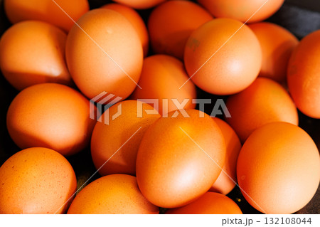 Fresh orange eggs collected from the farm during sunny morning hours ready for breakfast or baking 132108044