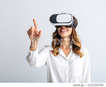 Woman wearing VR glasses and trying to touch something in the air, over white background 132108348