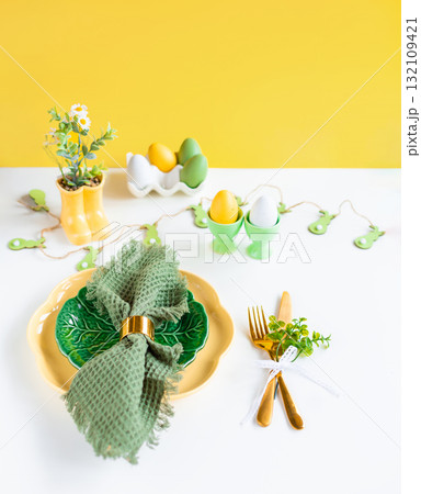Easter celebration concept. Top view vertical green yellow plate eggs, isolated background, banner 132109421