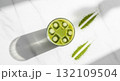 Overhead View Matcha Drink with Kiwi Slices and Powder Trails on White Marble Background 132109504