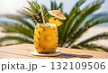 Pineapple Cocktail On Wooden Table With Blurred Beach And Palm Tree Backdrop 132109506