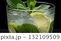Refreshing Cocktail Close Up with Lime and Mint in Transparent Glass with Black Background 132109509