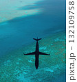 Aerial View Of Aircraft Shadow Over Turquoise Coral Reefs And Deep Blue Ocean Water Capturing Marine Environment 132109758