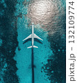 Aerial View Of White Airplane Over Turquoise Water Reflecting Sunlight And Sparkling Effects 132109774