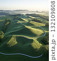 Aerial View Of Green Hill With Winding Path Bathed In Morning Light 132109808