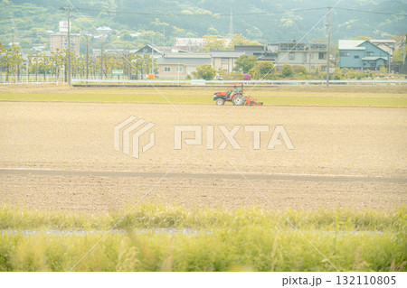 畑を耕すトラクター 132110805