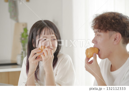 おやつの時間を楽しむ若いカップル 132112333