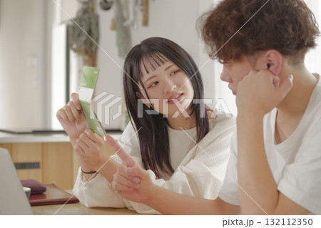 将来のお金の相談をする若い夫婦 132112350