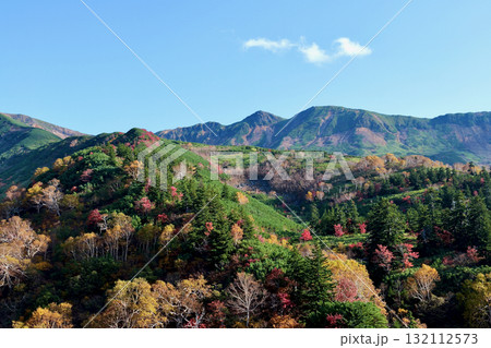 青空をバックに紅葉に染まる10月の十勝岳連峰「十勝岳温泉」から望む 132112573