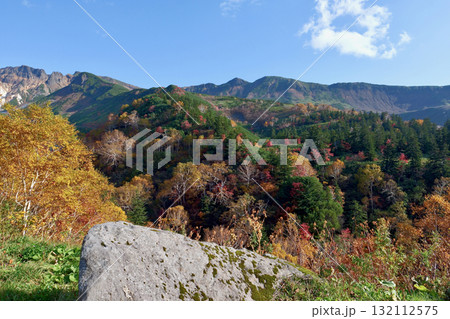 青空をバックに紅葉に染まる10月の十勝岳連峰「十勝岳温泉」から望む 132112575