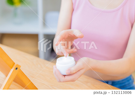 ビューティーイメージ　化粧品を手に取る女性の手元 132113006