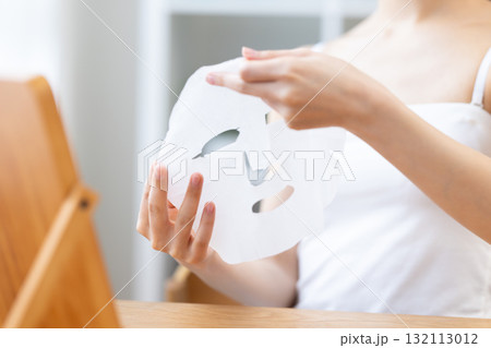 フェイスパックを手に取っている女性の手元 フェイスパックを手に取っている女性の手元 132113012