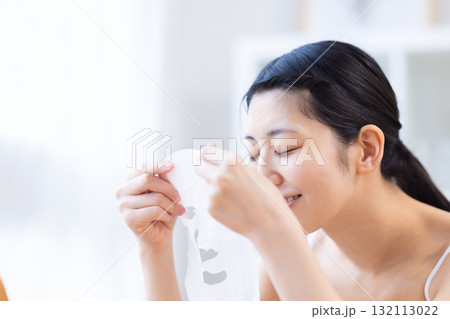 フェイスパックを手に取っている女性 フェイスパックを手に取っている女性 132113022