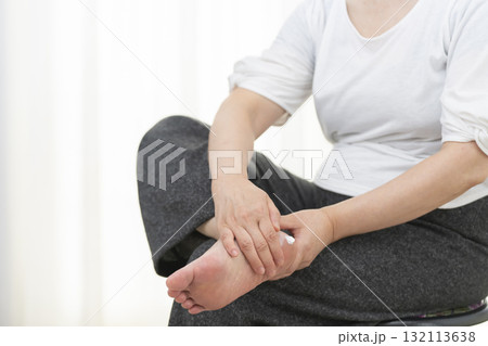 踵のカサつきにクリームを塗るシニア女性 132113638