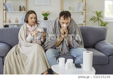 Sick couple suffering from fever and runny nose, cold and flu symptoms at home Sick couple suffering from fever and runny nose, cold and flu symptoms at home 132115210