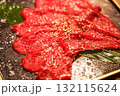黒皿に盛り付けられたごま付きの生牛肉スライス 132115624