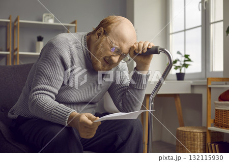 Depressed disappointed elderly man reading bad news from paper document or letter. Depressed disappointed elderly man reading bad news from paper document or letter. 132115930