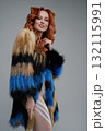 Beauty woman showcasing body art with colorful fur in a studio setting 132115991