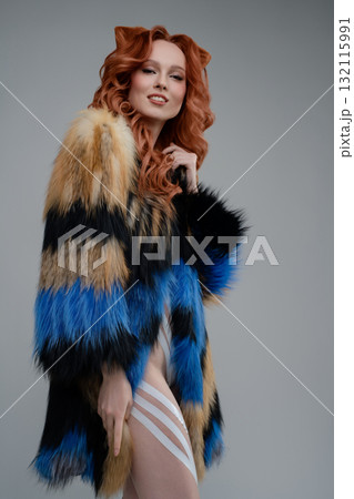 Beauty woman showcasing body art with colorful fur in a studio setting 132115991