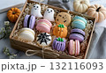 Colorful Halloween-themed macarons in a gift box decorated as ghosts, pumpkins, and spider webs 132116093
