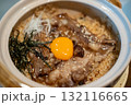 Beef fat fried rice in a bowl, with sliced meat and egg yolk on top 132116665
